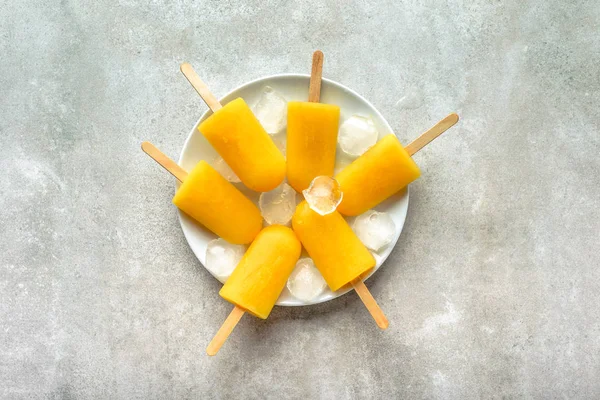 Orange popsicles. Homemade ice pops, overhead, flat lay