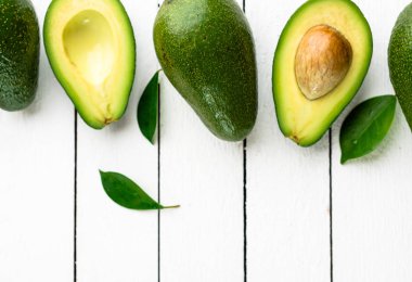 Beyaz ahşap zemin üzerinde taze avokado