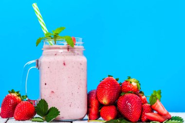 Sağlıklı güler yüzlü ile çilek, taze çilek ve süt ile sallamak