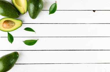 Beyaz ahşap zemin üzerinde taze avokado