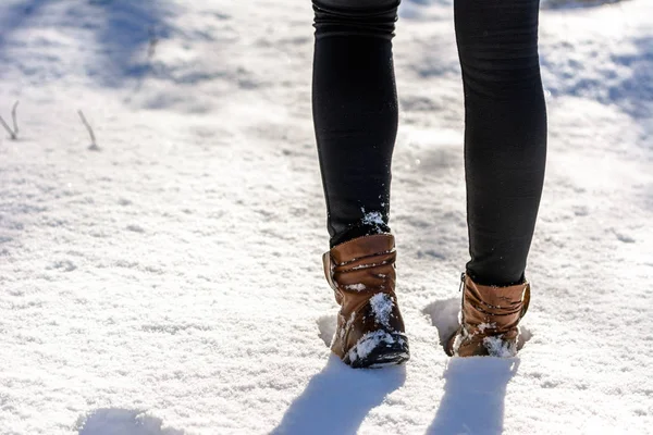 Woman in snow boots and leggings on legs, women\'s winter shoes