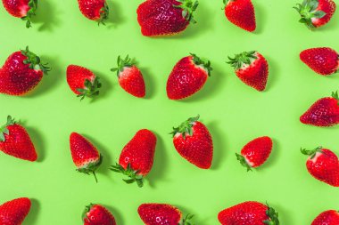 Renkli meyve deseni çilek yeşil arka planda, üstten görünüm