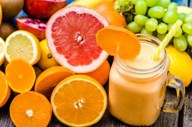 Tropikal meyve yüzlü portakal ve süt ile kavanoza sallamak