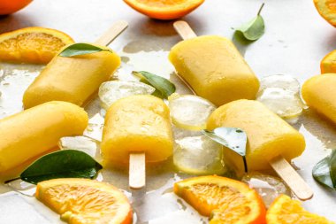 Dondurulmuş meyve suyu ve buz küpleri, yaz ferahlatıcı aperatif ile turuncu çubuklu dondurmayı