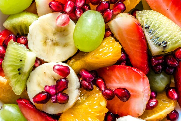 Refreshing summer fruit salad, colorful fruits background