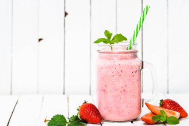 Beyaz arka plan üzerinde kavanoza meyve smoothie çilek, milkshake taze çilek ile harmanlanmış