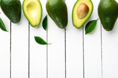 Beyaz ahşap zemin üzerinde taze avokado