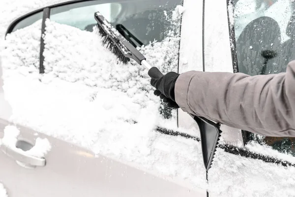 Mulher limpando carro da neve com escova. Pessoas em clima frio nevado no inverno e conceito de transporte . — Fotografia de Stock