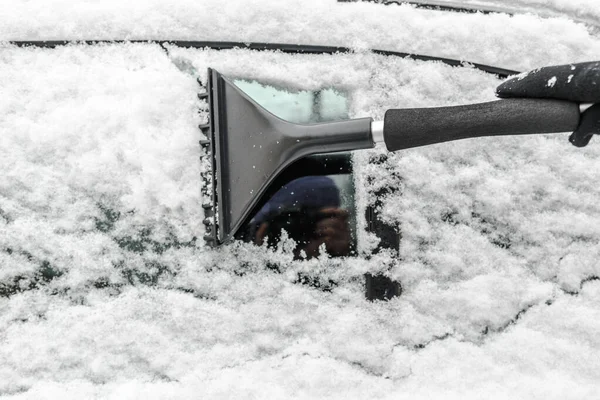 Mulher limpando carro da neve com escova. Pessoas em clima frio nevado no inverno e conceito de transporte . — Fotografia de Stock