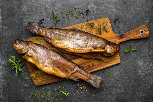 Rökt fisk med kryddor på mörk bakgrund — Stockfoto