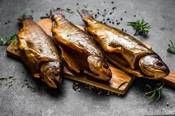 Rökt fisk med kryddor på mörk bakgrund — Stockfoto