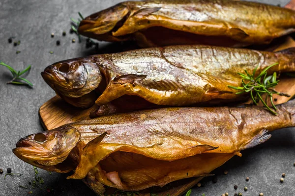 Rökt fisk med kryddor på mörk bakgrund — Stockfoto