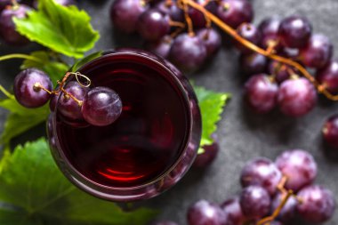 Taze üzüm ve kırmızı şarap kadehi, yakın plan, üst manzara.