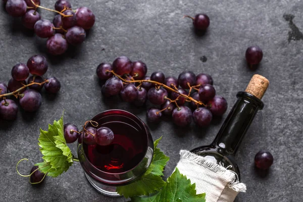 Fresh grapes, red wine glass and bottle, top view — Stock Photo, Image