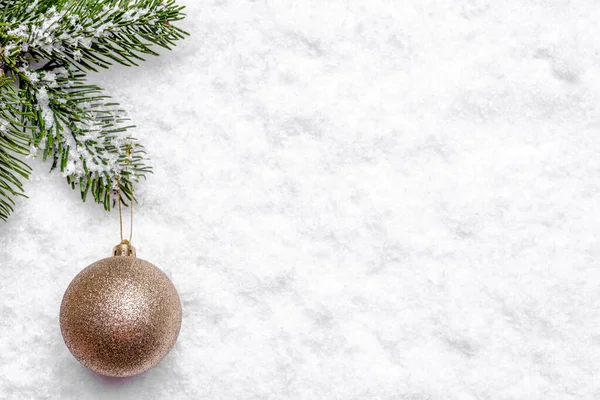 Χριστουγεννιάτικη μπάλα κρέμεται σε κλαδί από έλατο στο χιόνι, φόντο των Χριστουγέννων — Φωτογραφία Αρχείου
