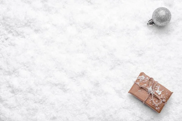 Karácsonyi fehér háttér ajándék doboz és karácsonyi dísz friss hó felületen, másolás tér — Stock Fotó