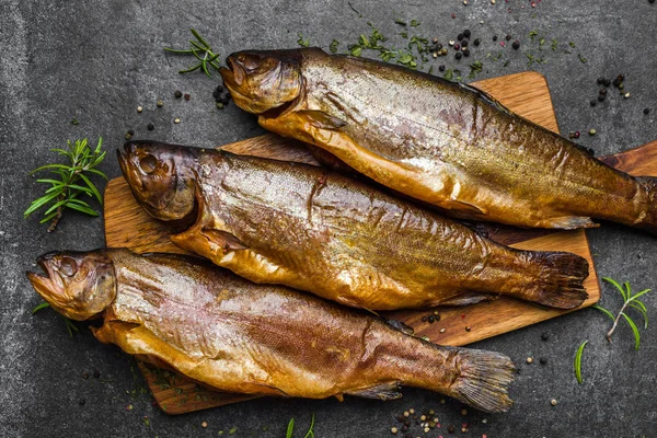 Rökt fisk med kryddor på mörk bakgrund — Stockfoto