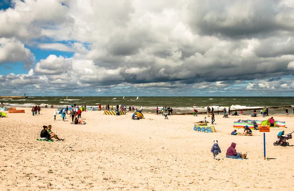 LEBA, POLAND - JULY 17, 2015: People enjoying at the beach in Leba city, bad weather, cloudy sky, Baltic sea, Poland - Stock-foto