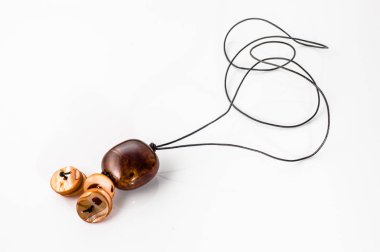 Pendant made with ceramics bead and leather straps isolated on a white background. Handmade jewelry.