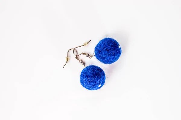 Örhängena formades. Handgjorda snygga filt smycken gjorda med blå filt pärlor isolerade på en vit bakgrund. — Stockfoto