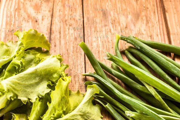 Свежие овощи. Органические свежие листья салата и зеленый стручок на деревянном фоне . — стоковое фото