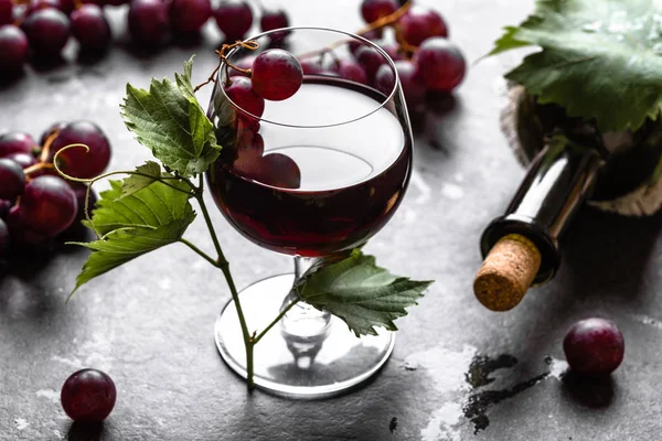 Garrafa de vinho e copo de vinho tinto com uvas — Fotografia de Stock