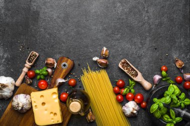 Italian food, cooking ingredients of spaghetti: pasta, tomatoes, basil, garlic, olive oil and cheese