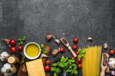 Italian food ingredients of spaghetti: pasta, tomatoes, parmesan, basil, olive oil, herbs and spices