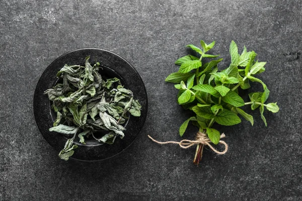 Foglie di menta fresca e menta secca su sfondo scuro . — Foto Stock