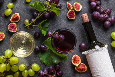 Farklı meyve ve şaraplar. Kadehler ve bir şişe şarap, üzüm ve incir..