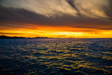 Denizin üzerinde gün batımı ile dramatik bir gökyüzü, Zadar, Dalmaçya, Hırvatistan ve Avrupa sahillerinden manzara