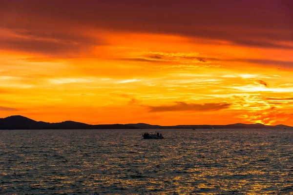Denizin üzerinde gün batımı olan altın gökyüzü, Zadar, Dalmaçya, Hırvatistan ve Avrupa sahillerinden manzara