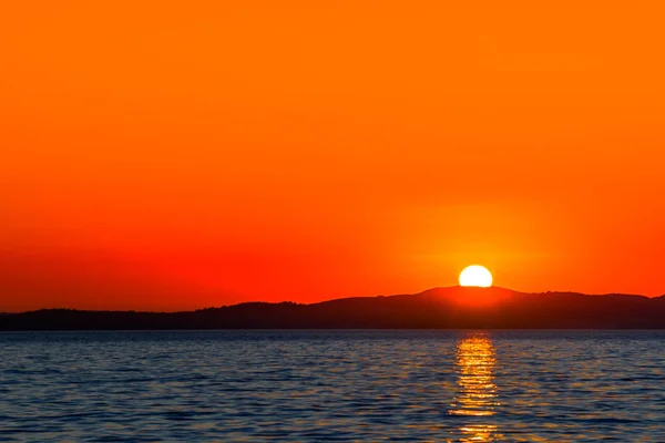 Оранжевый закат над морем с загоранием в воде, живописный вид, Задар, Далмация, Хорватия — стоковое фото