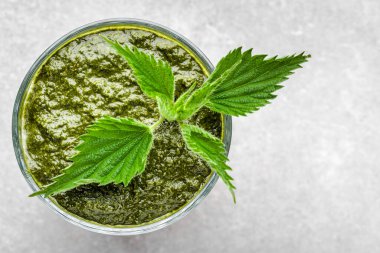 Beyaz arka planda yeşil ısırgan otu yapraklı sağlıklı bir smoothie.