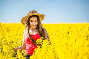 Baharda çiçek açan kolza tohumu tarlasında genç bir kadın.