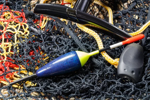 Flutuador de pesca de madeira com vara de pesca carretel e tanque de peixe no chão pedregoso — Fotografia de Stock