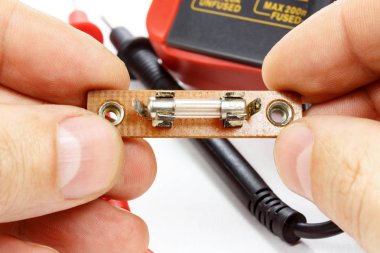 Bir elektrikçi beyaz bir arka plan üzerinde elinde sigorta