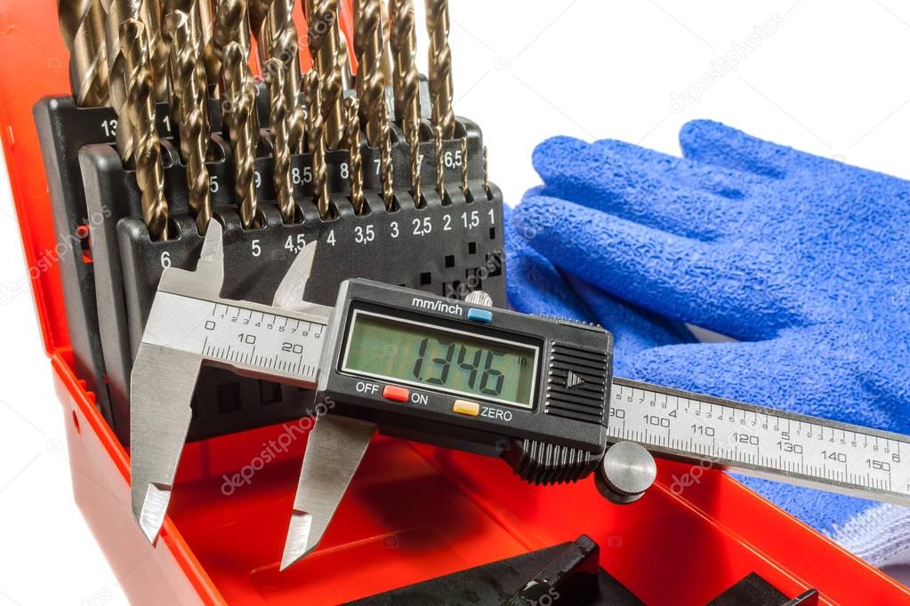 Digital caliper with set of drills on a white background