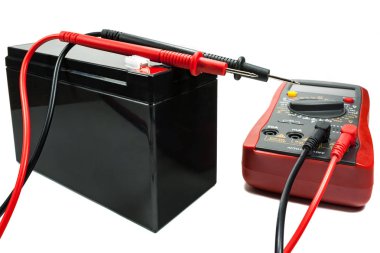 Bir multimetre ve beyaz zemin üzerine probları ile yedek pil