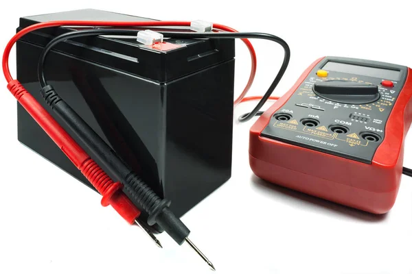 Bateria de backup com multímetro e sondas sobre fundo branco — Fotografia de Stock