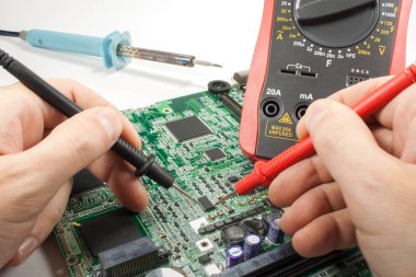 Dijital multimetre prob ve havya mühendisin elinde bir atölye ile