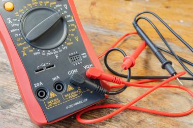 Bir tabloda bir atölyede bağlı probları ile dijital multimetre