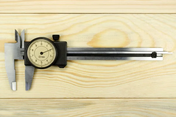 Měřicí nástroje třmen na dřevěný stůl — Stock fotografie