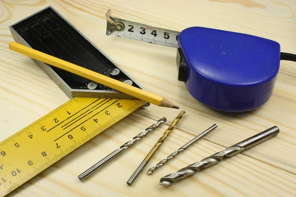 Herramientas de medición ruleta, regla y cuadrado en una mesa de madera — Foto de Stock
