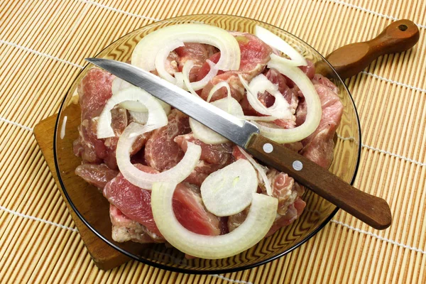 Stukken van vers vlees met uien en citroen — Stockfoto