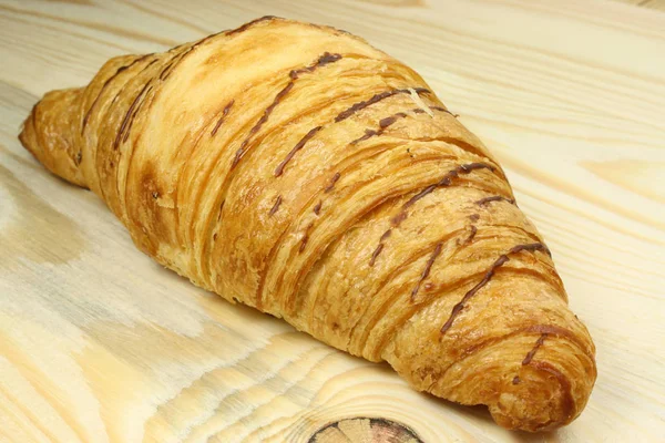 Fresh croissants on a wooden table — Stock Photo, Image