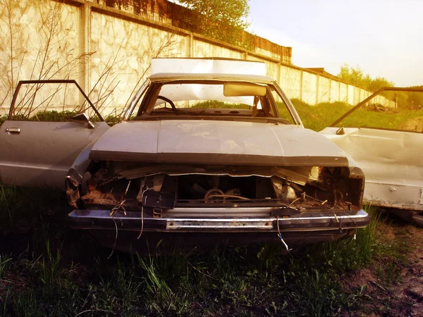 Desmantelou um velho carro enferrujado nos arredores da lixeira ao pôr-do-sol — Fotografia de Stock