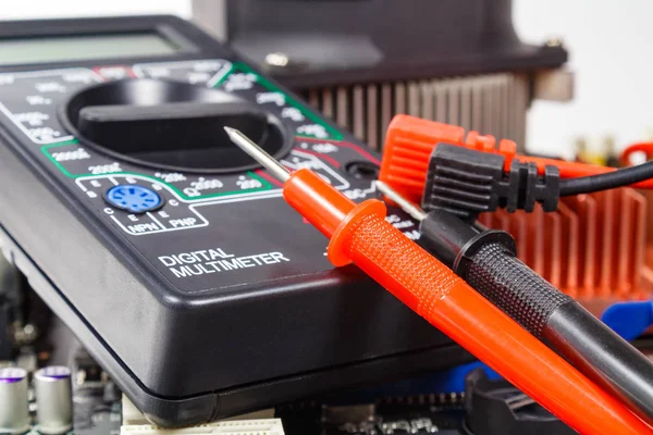 Digitales Multimeter mit farbigen Sonden auf der Computermotherboard Nahaufnahme — Stockfoto