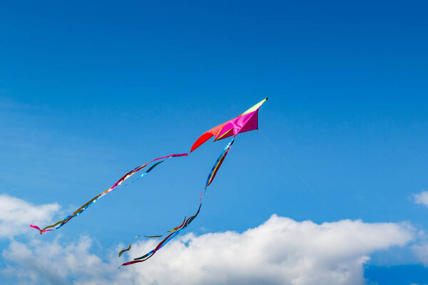 Flying kite on a blue sky background
