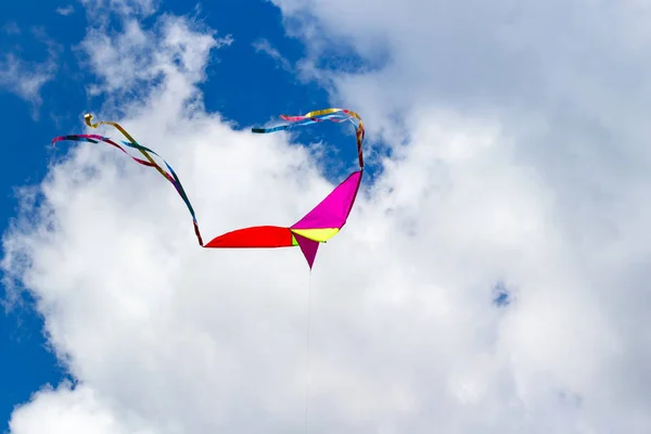 Flying kite on a blue sky background